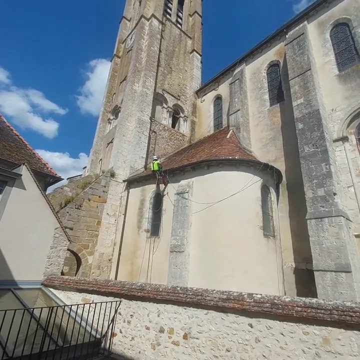 Vue de la façade avec un cordiste au bord de la toiture, extraite de la vidéo du chantier.