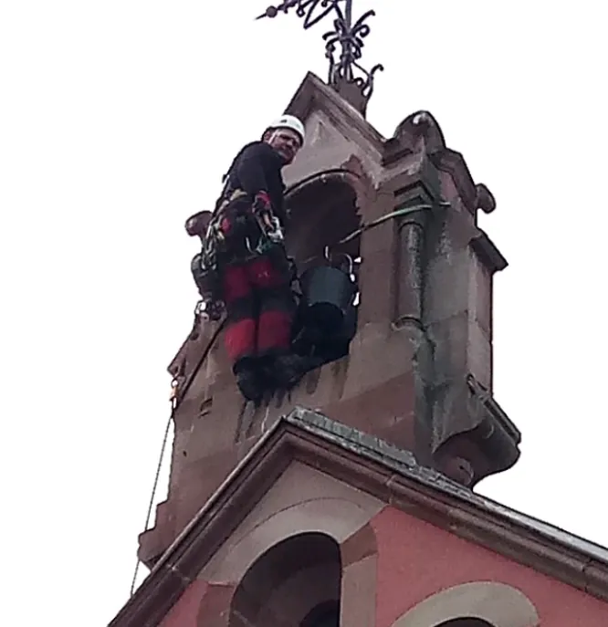 Cordiste en intervention près des ouvertures du clocheton de la chapelle Saint-Léon IX à Eguisheim.