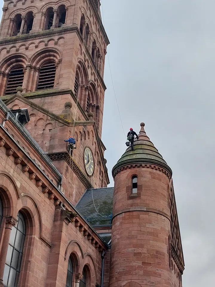 Cordistes en intervention au niveau du clocher et d’une tourelle de l’église protestante de Munster.